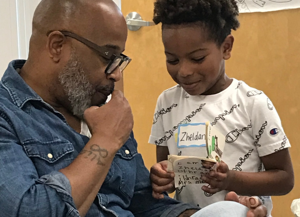 A man and child looking at a package of toothpaste.